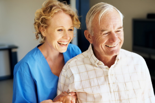 A young nurse helping her male senior patient go for a walk
